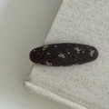 Dunkelbraune Filz-Haarklammer mit gestickter Schleife und Punkten auf Stoffhintergrund - Kaffee Oval Schleife Stil
