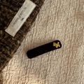 Detailed macro shot of a dark brown acetate hair clip with a golden poodle ornament - Pony Style (Black Pony BB Clip) / Black