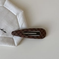 Detail einer braun karierten Haarspange aus Stoff mit Strickmuster und Metallrahmen - Kaffee Kariert Wassertropfen Stil