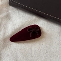 Detail einer Vintage weinroten Samt-Haarklammer mit Schleife auf strukturiertem Canvas - Weinroter Clip mit brauner Schleife