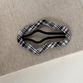 Detail of wave-shaped BB clip featuring black and white plaid fabric on a metal base - Black and White Striped Wavy Clip