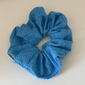 Detail of light blue knitted scrunchie showing hollow knit pattern and brand label - Large / Blue