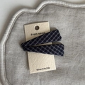 Detail of two plaid pattern hair clips in dark blue fabric on a neutral card base - Navy White Striped