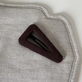Detailed top view of ribbed knit fabric bb hair clip in deep burgundy on grey textured base - Large Triangle Hair Clip / Khaki