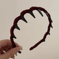 Detail of red knit headband featuring gothic black spikes and soft fabric texture - Non-Slip Toothed Headband / Brick Red