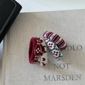 Dettaglio di quattro elastici per capelli in maglia con motivi di alce e righe su un libro - Set 1 Stile a Pois Multicolore
