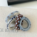 Close-up of four knitted elastic scrunchies with heart patterns and textured woven fabric - Set 3 Blue Series Style
