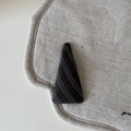 Macro shot of vintage striped triangular hair clip on natural beige linen background - Khaki Blue Striped Triangle Style