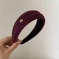 Dettaglio della fascia in maglia bordeaux con targhetta in metallo LOVE e trama a coste - Fascia a Costine Etichetta Oro / Borgogna