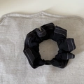 Elastische zwarte scrunchie met witte stiksels en ovale sluiting op grijze stof - Geplooide scrunchies / Zwart Zilver Gestreept Scrunchie