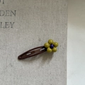 Dettaglio del fermaglio a fiore con petali verde oliva e centro viola su base clip BB - Fiore Giallo Clip Cachi