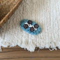 Dettaglio di un fermaglio per capelli blu all'uncinetto con design a biscotto panna - Tema Biscotti / Bordo in Lana Blu con Quattro Punti Neri