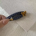 Dettaglio del fermaglio per capelli a scacchi blu scuro con un fiocco giallo laterale - Fermaglio Ovale Plaid Blu Marino Fiocco Giallo