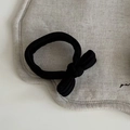 Detalle de un coletero de tela acanalada negra con un lazo vintage de estilo minimalista - Goma de Pelo con Lazo Negro
