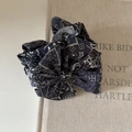 Gros plan sur une pince à cheveux en tissu paisley rétro sur un fond de livre ancien - Nœud Paisley Bleu Marine