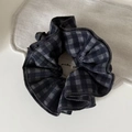 Detail des Vintage-Haargummis mit dunkelrotem Karomuster und weicher Stofftextur - Schwarzes Karo
