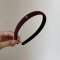 Dettaglio della fascia in maglia bordeaux con piccolo ornamento a cuore in oro - Viola