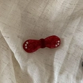 Detail view of a vintage red acetate bow hair clip with sparkling rhinestone accents - Red Textured Style