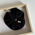 Close-up of black oversized scrunchie with Hand Made woven label on a wooden tray - Black Striped