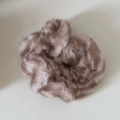 Primer plano de un coletero de peluche malva suave con textura de piel sintética - Anillo de Pelo de Felpa a Rayas Café Rosa