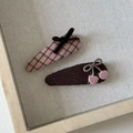 Détail de barrettes à carreaux roses et marron café avec nœuds sur fond de lin naturel - Style Broderie Cerise (3#)