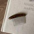Macro detail of tortoiseshell acetate hair comb with 12 silver metal teeth on linen cloth - Blue Tortoiseshell