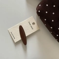 Close-up of a glossy brown oval hair claw clip displayed on a branded white card - Coffee Long Oval Hair Clip