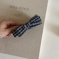 Detailed close-up of a black and white plaid bow hair clip featuring a vintage gold center buckle - Blue & White Stripes