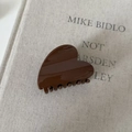 Pinza para el cabello brillante marrón oscuro en forma de corazón sobre tela beige - Pinza de Pelo Corazón de Acrílico Café