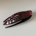 Vista superior de una pinza para el cabello de acetato con textura de mármol rojo y negro - Clip de Textura Vino Tinto