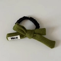 Detalle de lazo de punto oliva con etiqueta Nice sobre un coletero negro plisado - 5# Lazo Verde Goma Pelo