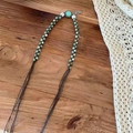 Détail de collier tressé bohème avec perles vertes et pendentif feuille sur bois - Pendentif Feuille à Perles Bleues