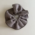 Macro detail of a grey knit scrunchie featuring decorative black wavy edge stitching - Milk Tea