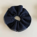 Detailed view of dark blue knitted hair scrunchie with grey stitched edge texture - Navy Blue