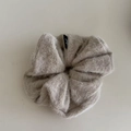 Minimalist beige knitted scrunchie hair tie with soft texture and small woven brand label - Milk Tea Plush Style