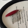 Detail showing 'FRANCE Handmade' inscription on a red resin hair comb with metal teeth - Red Curved Hair Comb