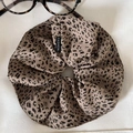 Detailed close-up of leopard print satin hair scrunchie with fashion label on white fabric - Light Leopard (Large)