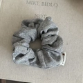 Dettaglio di un elastico per capelli in tweed grigio con etichetta del marchio di lusso - Scrunchie Spina di Pesce Grigio Chiaro