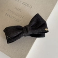 Dettaglio fermaglio per capelli a fiocco grigio scuro con medaglietta d'oro su libro - Fermaglio a banana a fiocco / Nero