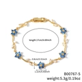 Pulsera de flores doradas con circonitas azules y hojas blancas en una cadena ondulada - Estilo de Flor Azul y Estrás Transparente en Tono Dorado (B00767-5)