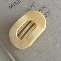 Detailed macro view of cream marble hair claw clip with internal grip teeth structure - 4# Creamy Yellow Oval Claw