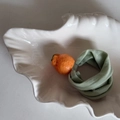 Dettaglio dell'elastico per capelli con arancia su piatto bianco e fascia verde - Elastico Verde Arancia
