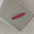 Detail of pink enamel BB hair clip with small square blue gemstone on a white tray - Rose Red Waterdrop Clip (Blue Crystal)
