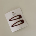 Close-up of deep burgundy tortoiseshell BB hair clips on white embossed display card - Coffee