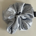 Vue détaillée d'un chouchou en satin bleu gris à pois avec une étiquette de mode - Style à Pois / Bleu