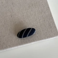 Detailed view of an oval navy striped fabric hair clip on a natural linen surface - Blue White Striped Small Oval Clip (12#)