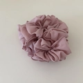Detail of light pink pleated chiffon scrunchie with layered petal structure on beige background - Pink