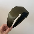 Detailed view of wide dark green satin headband featuring smooth silk texture and black lining - Shiny Green