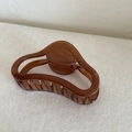 Pinza para el pelo curva marrón translúcido con diseño ondulado elegante de mujer - café