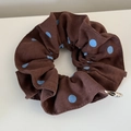 Detailed view of the brown scrunchie with light blue polka dots and pleated cotton texture - Scrunchie
